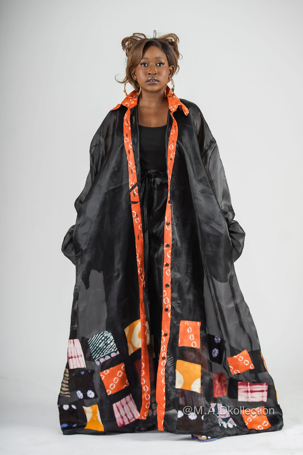A model wearing a black organza shirt dress with  multicolor patches. african inspired fashion
african clothing for women, ankara fashion